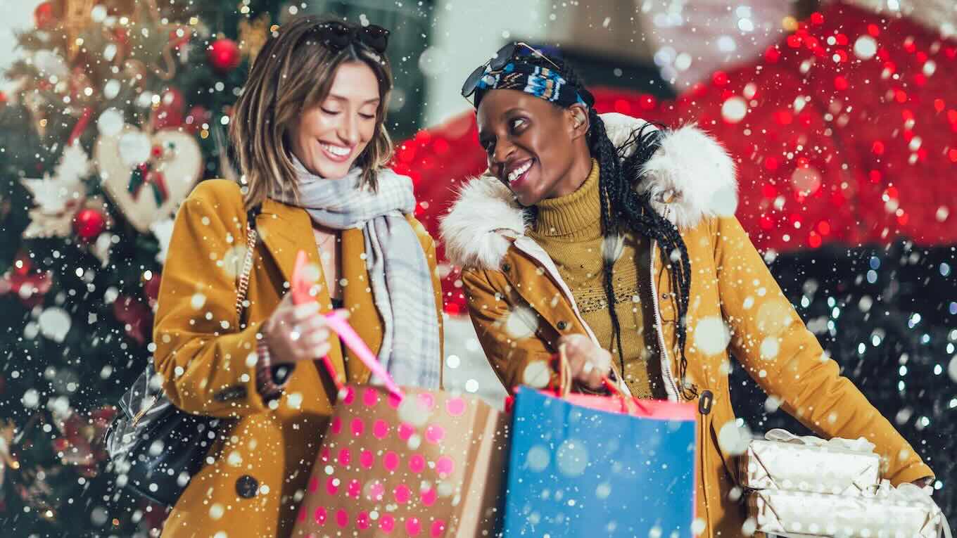 Two people in winter clothing hugging each other.