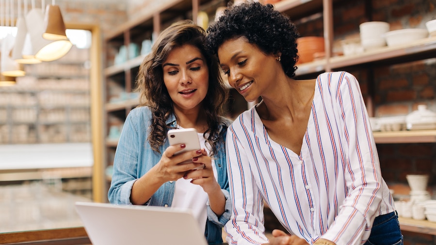 Two female business owners reviewing their cash flow.