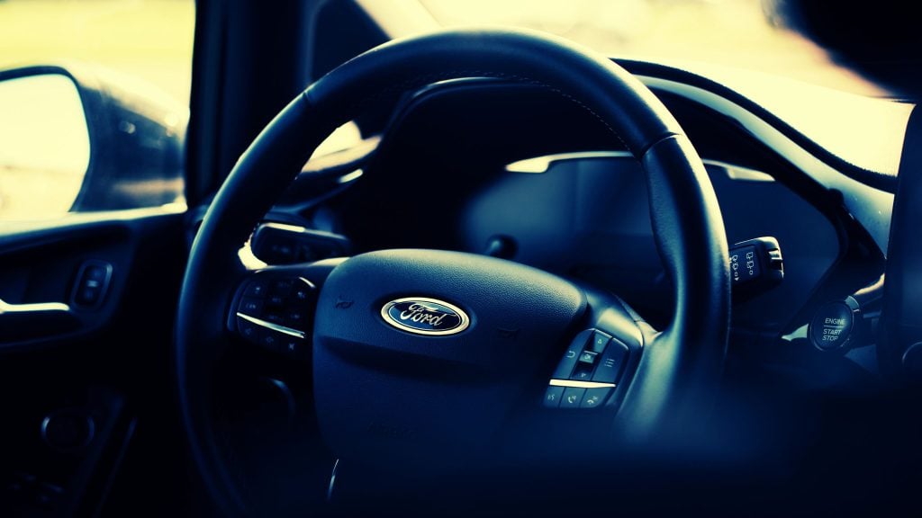 Close-up of a Ford vehicle's steering wheel with the logo prominently displayed.