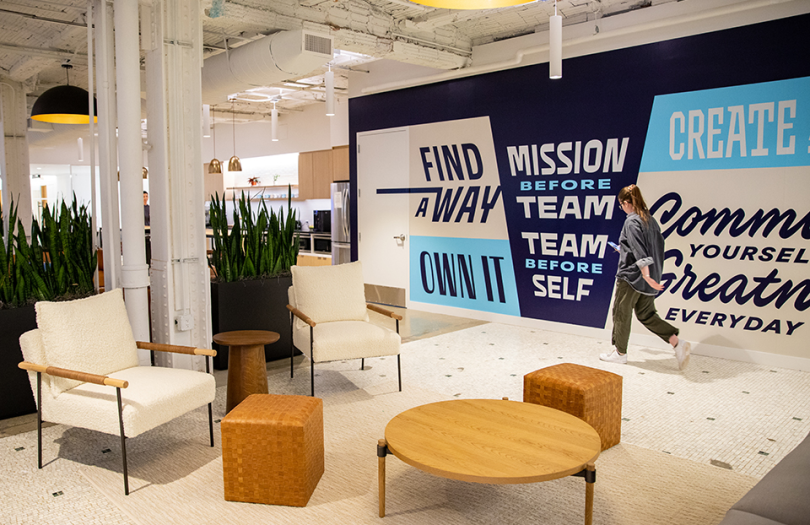 An Orchard employee walking past the values mural in the NYC office