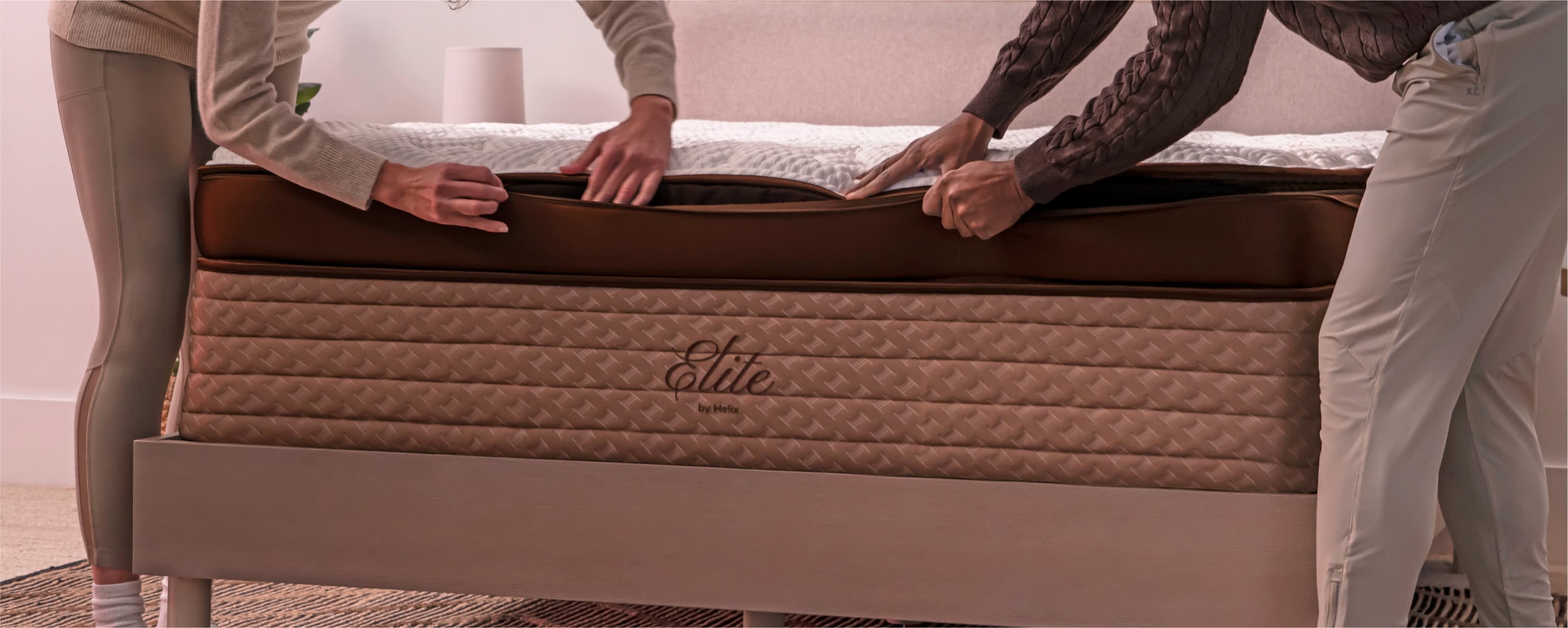 Two people zipping up the Helix Elite mattress