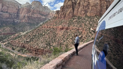 Man Looking Out Over A Canyon Next To A Parked Camper Van