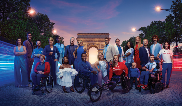 Channel 4’s 2024 Paralympics team in Paris, in front of the Arc de Triomphe and long exposure streaks of red and blue light  