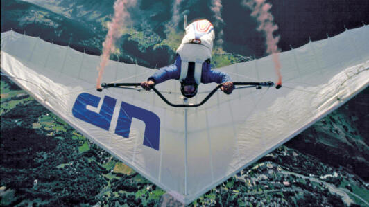 L’Américain Éric Raymond, dans une série de loopings à bord de son deltaplane Comet, à la verticale de Fiesch, dans le Haut-Valais, en 1984.