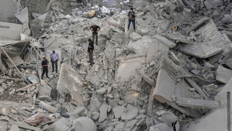 Des gens fouillent les décombres d'un immeuble touché par un bombardement dans le quartier de Danyeh à Beyrouth, le 2 octobre 2024.