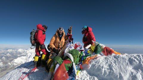 Sur cette photo prise le 17 mai 2018, des alpinistes et des sherpas se rassemblent au sommet de l'Everest après l'ascension par la face sud, depuis le Népal.