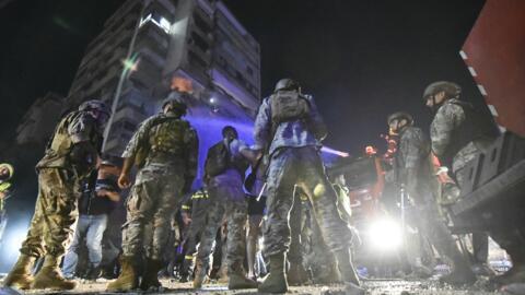 Des soldats de l'armée libanaise sécurisent le site à l'extérieur d'un immeuble touché par une frappe aérienne israélienne dans le quartier de Cola à Beyrouth, le 30 septembre 2024.