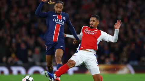 Bradley Barcola stoppé par un tacle de William Saliba. Paris chute sur la pelouse d'Arsenal.