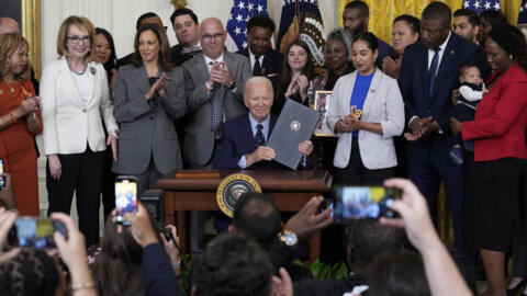 Le président Joe Biden, accompagné de Kamala Harris, brandit le décret qu'il a signé sur la violence armée aux États-Unis, à la Maison-Blanche à Washington, le 26 septembre 2024.