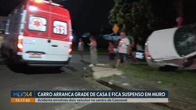 Carro arranca grade de casa e fica suspenso em muro - Acidente envolveu dois veículos no centro de Cascavel