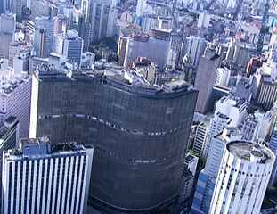 A repórter Cinthia Toledo sobrevoa o Edifício Copan, obra de Oscar Niemeyer, durante a cobertura da morte do arquiteto. Em seguida, Beatriz Thielmann lê uma carta de Chico Buarque para o amigo falecido, Bom Dia Brasil, 06/12/2012 .