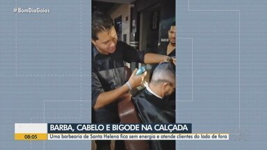 Barbearia atende clientes na calçada após queda de energia em Santa Helena - Segundo proprietário do estabelecimento, eletricidade foi interrompida depois de um temporal.