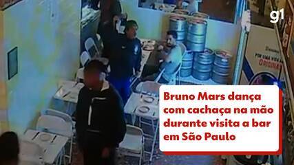 Bruno Mars dança com cachaça na mão durante visita a bar em São Paulo