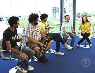 Ana Paula Araújo e o comentarista Fábio Júdice entrevistam diretamente do estúdio de vidro montado no Rock in Rio a banda Móveis Coloniais de Acaju, a primeira a se apresentar naquela noite no palco Sunset, RJ TV 1ª edição, 23/09/2011.