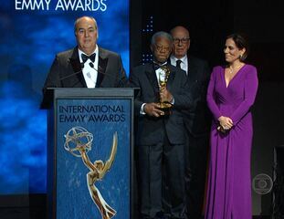 Reportagem de Hélter Duarte sobre o recebimento do Emmy Internacional por Roberto Irineu Marinho, na categoria Personalidade Mundial da Televisão. Há 30 anos seu pai, Roberto Marinho, foi homenageado com o mesmo prêmio. Jornal Nacional, 25/11/2014.