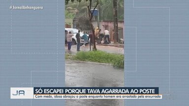 Idosa abraça poste para escapar de enxurrada em Goiânia - Enquanto isso, homem foi levado pela enxurrada e ficou preso embaixo de uma caminhonete.