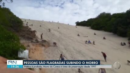 Banhistas sobem área proibida do Morro do Careca, em Natal