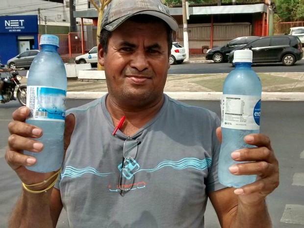 Luis mostra a água congelada que oferece aos candidatos na porta de escola (Foto: Carlos Palmeira/ G1)