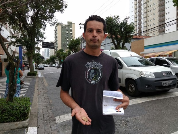 Homem levou carteira de trabalho para as ruas para pedir ajuda em Santos (Foto: Guilherme Lucio da Rocha / G1)