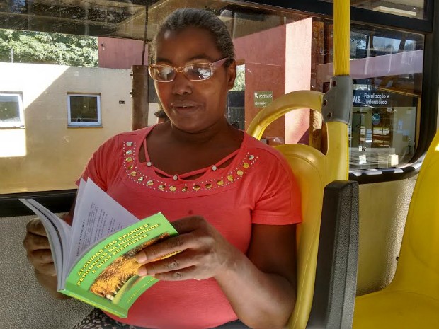 A servidora pública Marlene de Oliveira, que já costuma ler a Bíblia, diz que agora poderá diversificar a leitura com os livros disponíveis nos ônibus (Foto: Fabiula Wurmeister / G1)