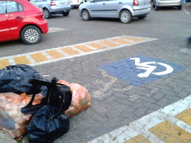 Sacos de lixo ocupam vaga exclusiva para deficientes no estacionamento da Unip, em Brasília (DF) (Foto: Liliane Lopes/VC no G1)