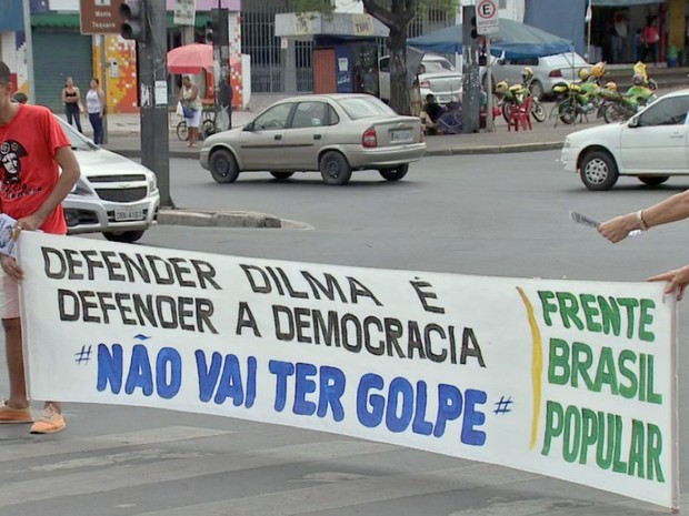 Manifestantes seguram faixas nos semáforos em Cuiabá (Foto: Reprodução/ TVCA)