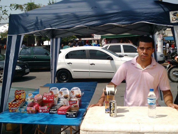 Lucas Souza disse que chega a faturar R$ 3 mil com vendas de água, canetas e chocolates (Foto: Lislaine dos Anjos/ G1)