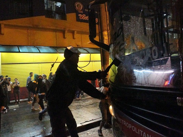 Manifestante depreda ônibus na região central de São Paulo durante protesto contra o aumento da passagem (Foto: Daniel Teixeira/Estadão Conteúdo)