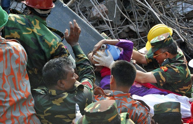 Equipe de resgate auxilia retirada da sobrevivente após 17 dias sob os escombros do prédio desmoronado, em Bangladesh (Foto: Parvez Ahmad Rony/AP)