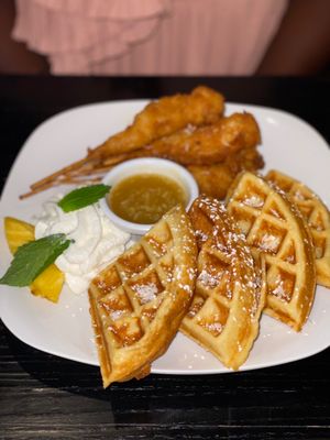 Photo of ININE Bistro - New York, NY, US. a plate of waffles and fried chicken