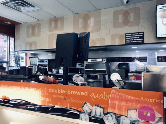 Photo of Dunkin' - New York, NY, US.  a restaurant counter with a large orange sign