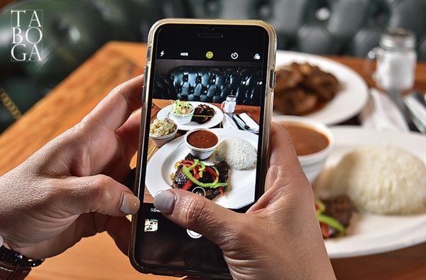 Photo of Taboga - New York, NY, US. a person taking a picture of a plate of food