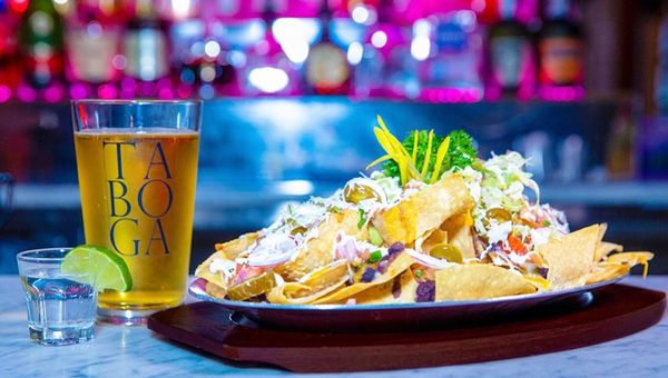 Photo of Taboga - New York, NY, US. a plate of nachos and a glass of beer