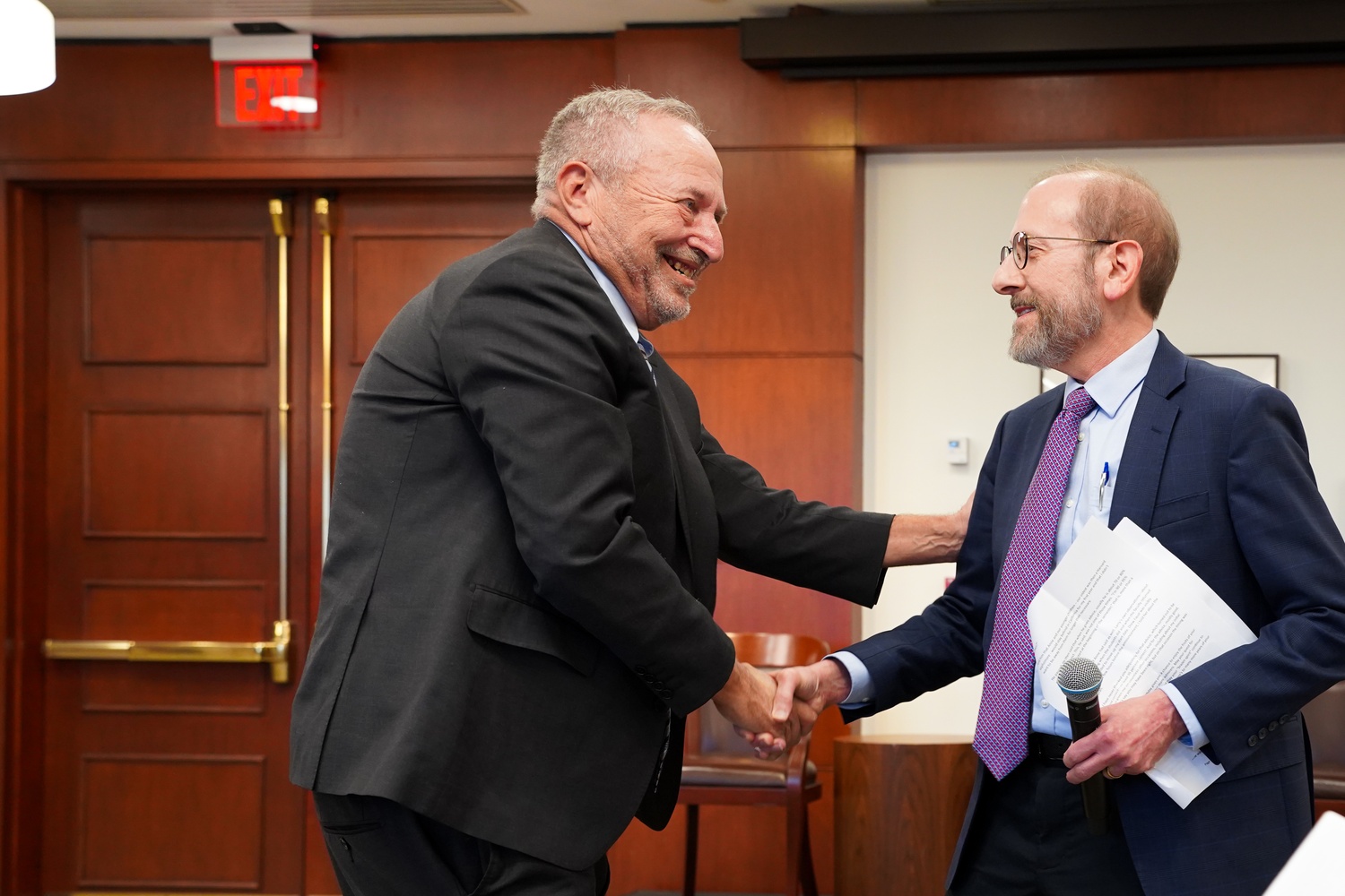 Former University President Lawrence H. Summers greets Harvard President Alan M. Garber '76 at his 70th birthday symposium on Friday. Garber teased Summers during a largely comedic address during the conference.