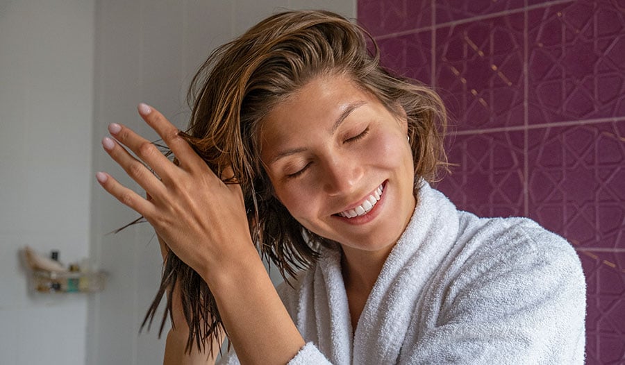 woman with healthy short hair taking care of her scalp