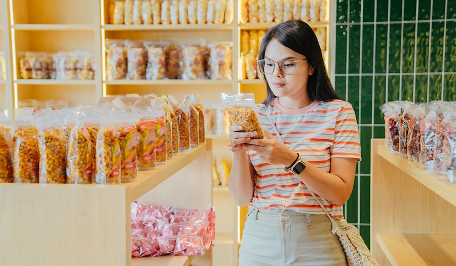 Woman looking at food label in grocery store