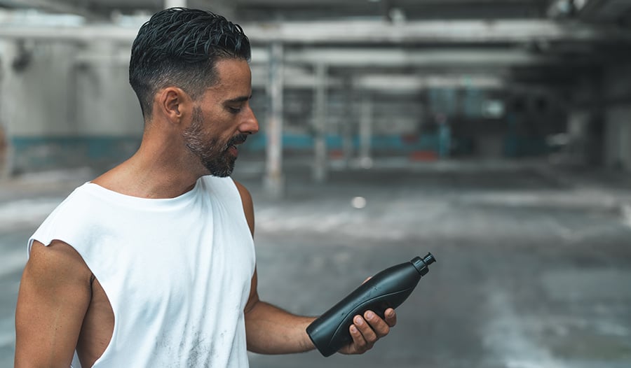 Athletic male working out holding water bottle