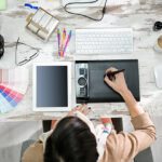 woman designer working on the pen table in office top view