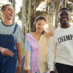 Three Curtin University students walking campus and smiling.