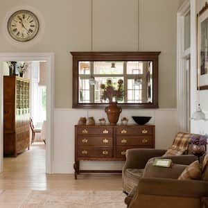 An antique wooden drawers and mirror in hallway