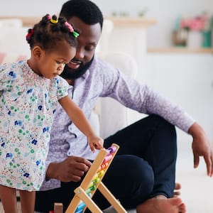 Father plays with his little girl on the carpeted floor