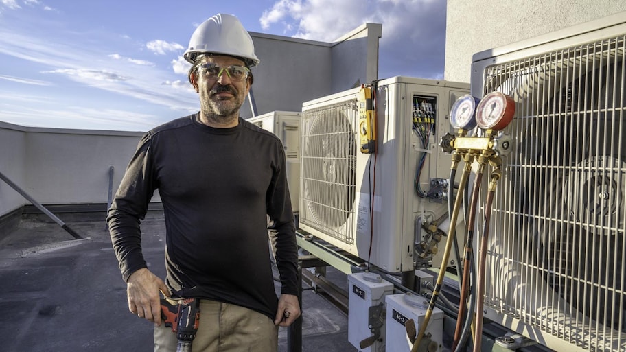 HVAC technician standing next to ac