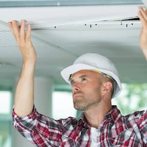 Man installing suspended ceiling  