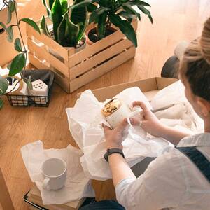 woman sitting on the floor packing her belongings