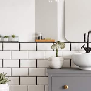 A bathroom with white porcelain tiles and plants