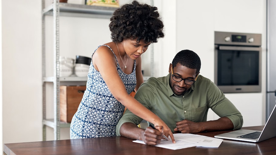 Couple reviewing printed contract at home