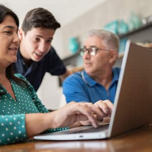 Parents and teenager son doing home finances at home