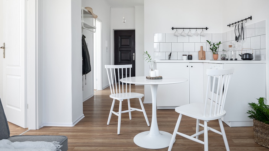 white kitchen with round table and bamboo flooring