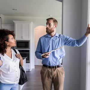 A man showing new home to a couple