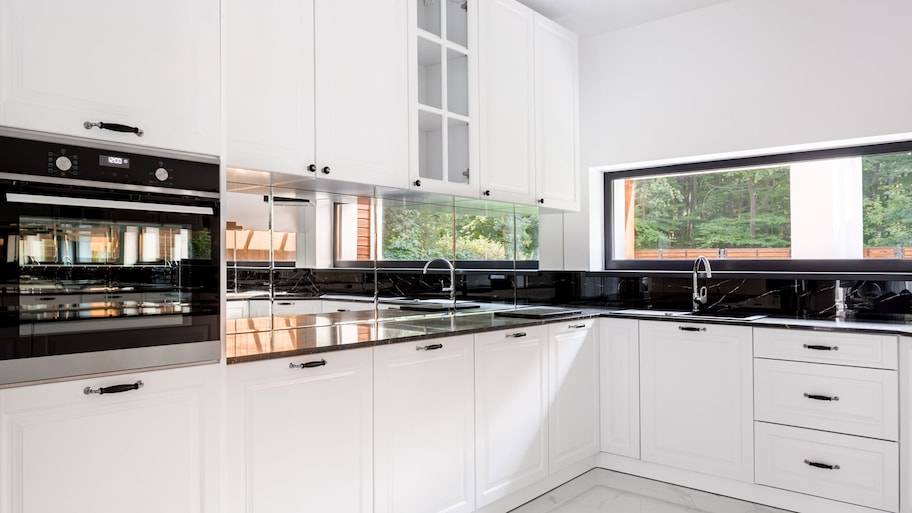 A mirror backsplash used in a bright kitchen